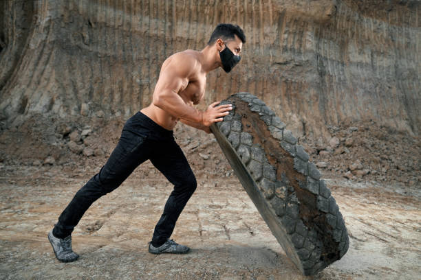istock Healthy man with athletic body pulling wheel outdoors 1292366636