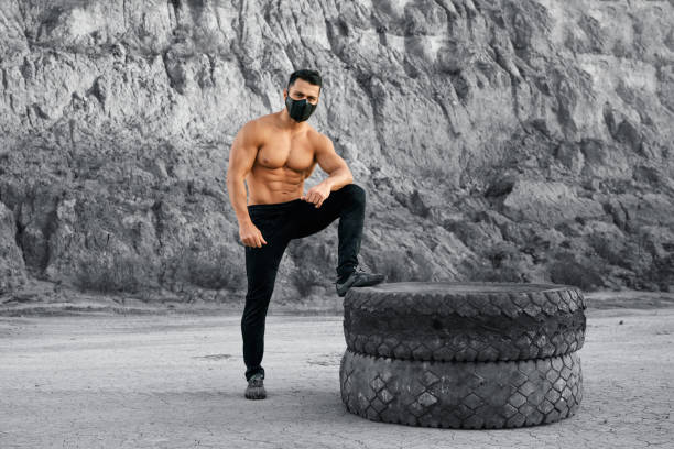 istock Bodybuilder with bare torso posing near tyres outdoors 1292366744