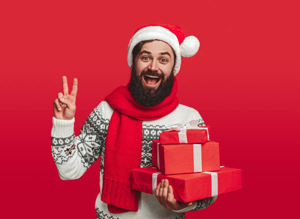 istock Happy man with Christmas presents showing peace sign 1292366966