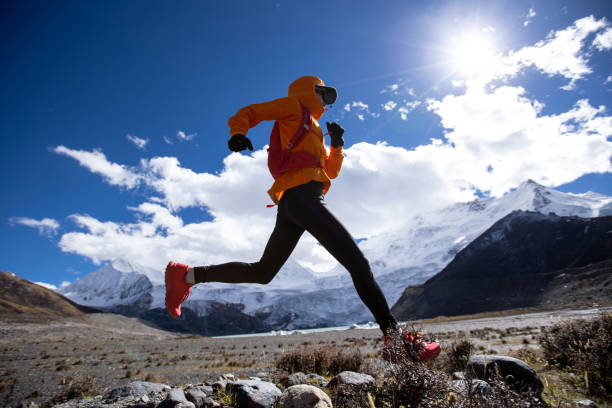 mulher trail runner cross country correndo em alta altitude natureza inverno - exploration mountain ice jumping - fotografias e filmes do acervo
