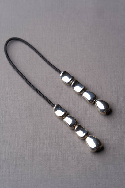 istock Leather necklace with silver pendant on gray background 1292369187