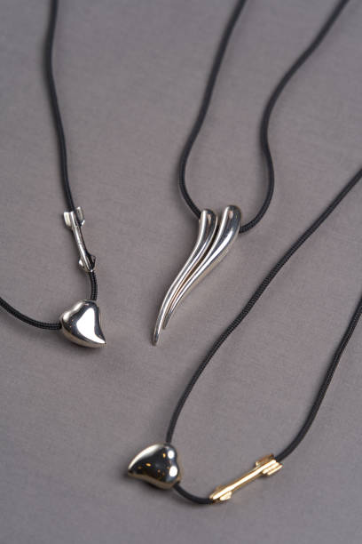 istock Leather necklace with silver pendant on gray background 1292369194