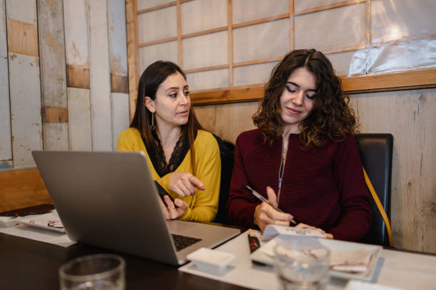 istock Females gathering in table restaurant with computer. 1292370250