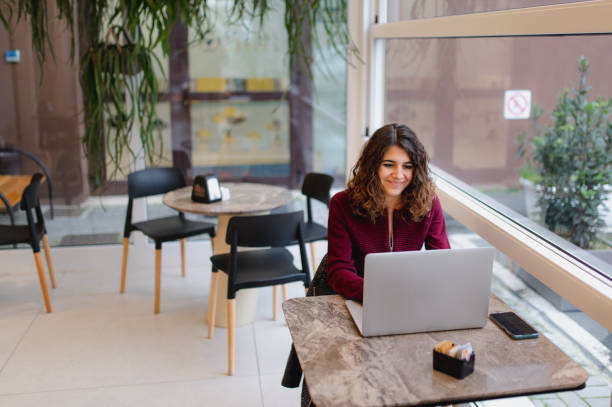 istock woman in a cafe sitting at the table using computer laptop. 1292370601