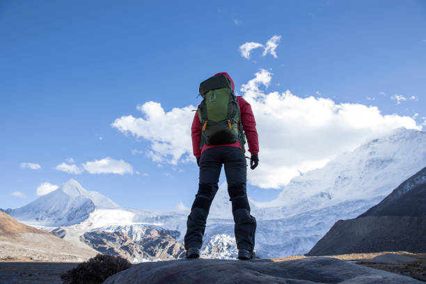 istock Successful woman backpacker hiking in winter mountains 1292370697