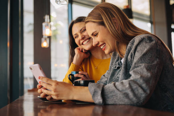 istock Friends at cafe using phone and smiling 1292371765