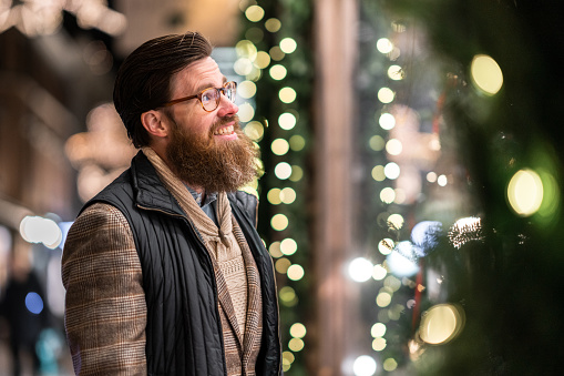 Man doing some Christmas shopping. He is looking in through the store window.