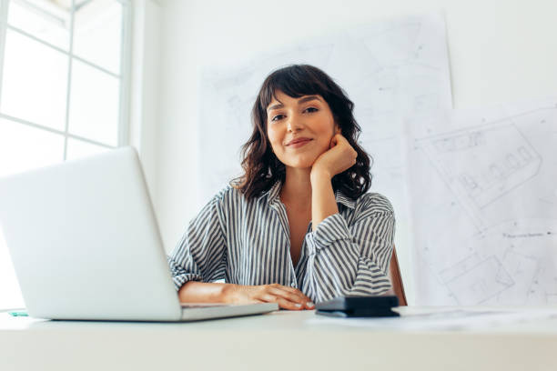 istock Woman architect sitting at office desk 1292373293