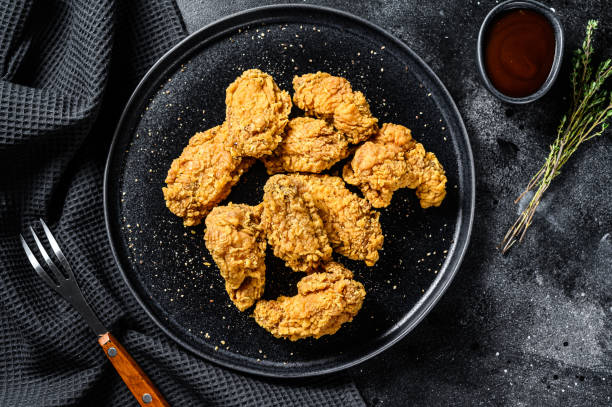 istock Crispy barbecue chicken wings on a black plate. Black background. Top view 1292374017