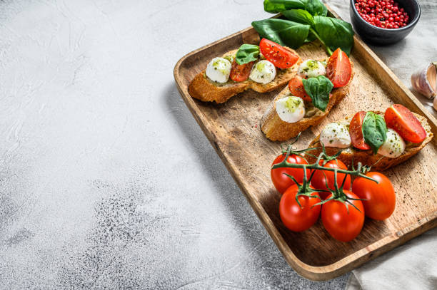 Bruschetta with tomatoes, mozzarella cheese and basil. italian appetizer or snack, antipasto. gray background. top view. Copy space