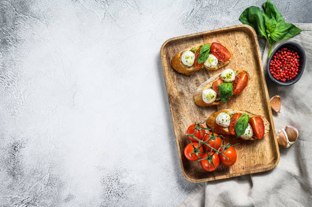istock Bruschetta with tomatoes, mozzarella cheese and basil. italian appetizer or snack, antipasto. gray background. top view. Copy space 1292374060