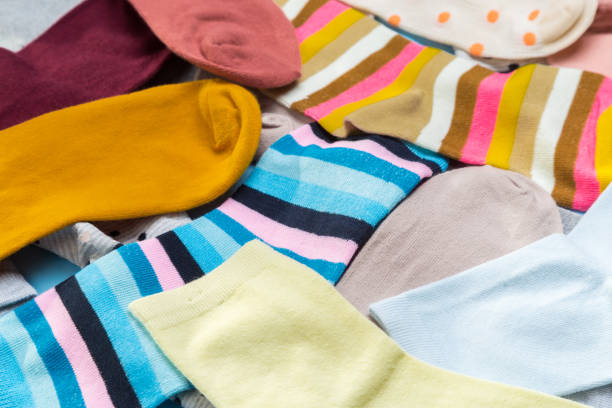 istock Many multicolored new socks stacked against a blue background. top view. place for text. 1292377736