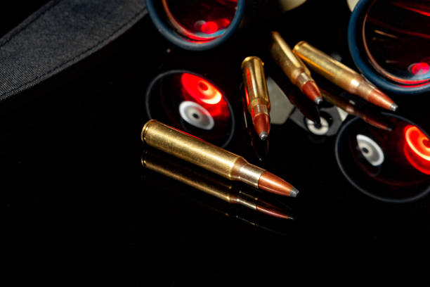 istock Military binoculars and cartridges on mirror background 1292378113