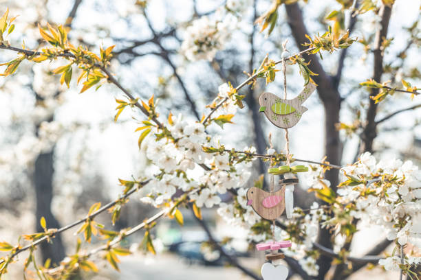 istock Easter decoration on blurred cherry tree background with spring flowers in sunny day. Spring background art with white blossom, shallow depths of the field 1292378755