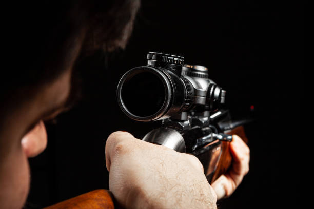 istock Unrecognizable man aiming with a hunting rifle in dark 1292380333