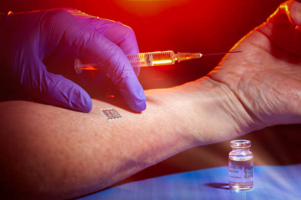 istock Conspiracy theory concept with identification chip being implanted in patient's arm during COVID-19 vaccination 1292382608