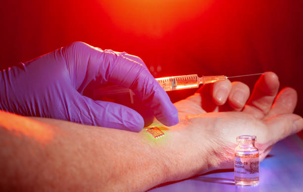 istock Conspiracy theory concept with identification chip being implanted in patient's arm during COVID-19 vaccination 1292382624