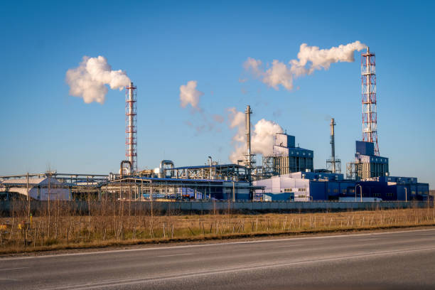 rohre mit riesigen rauchwolken in der fabrik gegen den blauen himmel an einem sonnigen tag, foto von der straße. konzept der ökologie, umweltverschmutzung - old station natural gas russia stock-fotos und bilder