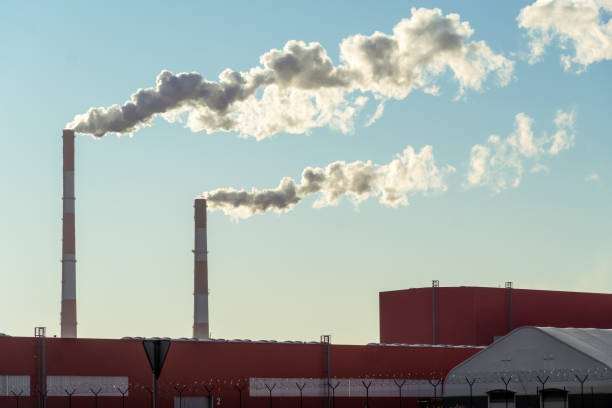 canos com enormes nuvens de fumaça na fábrica de perto contra o céu azul em um dia ensolarado. conceito de ecologia, poluição ambiental - old station natural gas russia - fotografias e filmes do acervo