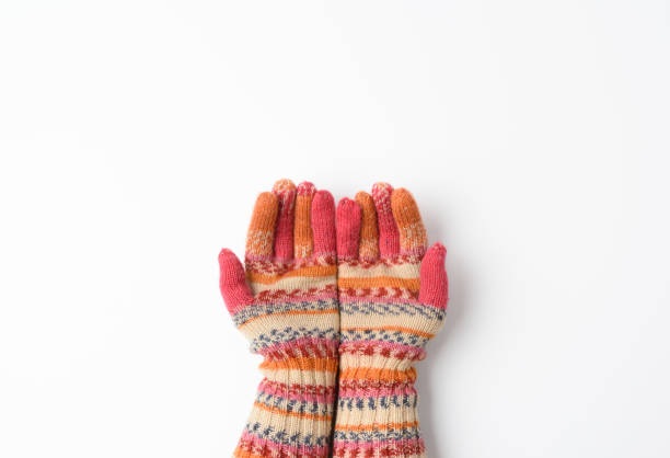 two female joined palms in knitted multi-colored mittens on a white background, top view