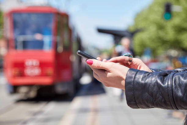 istock Woman using cellphone on a tram station in Europe. 1292390543