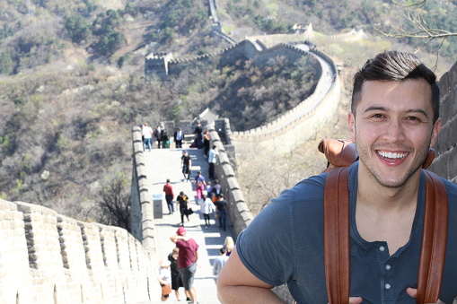 Excited tourist visiting the great wall of China.