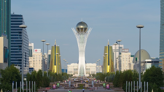 The city of Astana timelapse, residents are walking and relaxing on a sunny day near boulevard with fountains at the symbol of the city - Baiterek area presidents palace in the background. Astana, Kazakhstan