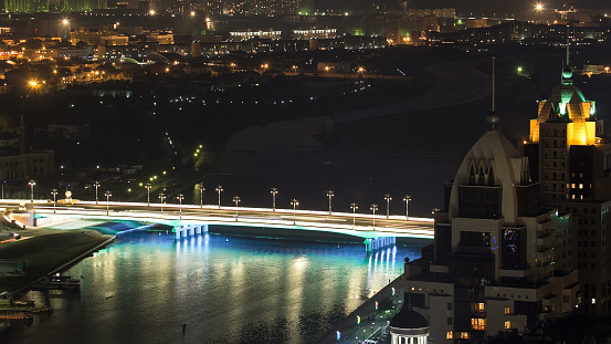 River and illuminated bridge timelapse from rooftop at night in Astana. Kazakhstan capital 4K