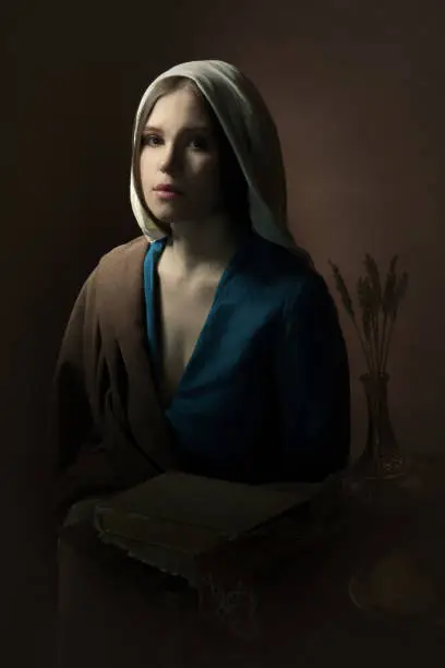 Portrait of a young girl who looks into the camera. Renaissance. A woman in a retro dress. Historical reconstruction.