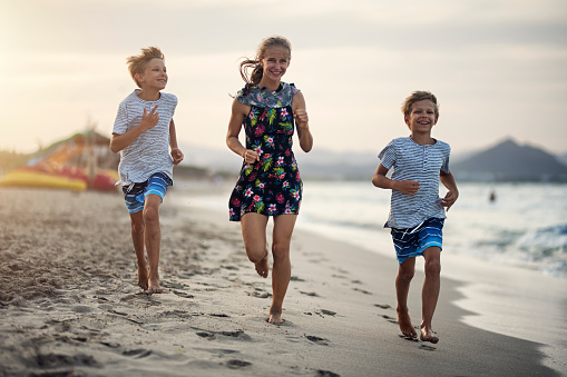 Happy kids running on a beach. Three kids enjoying time on a beautiful beach.
Nikon D850