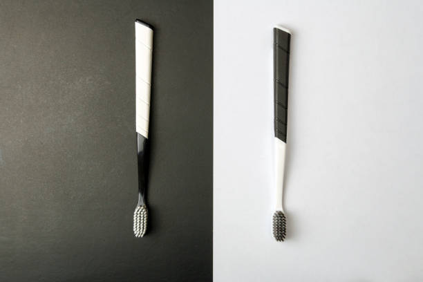 istock Two black and white toothbrushes on a monochrome background. 1292398396