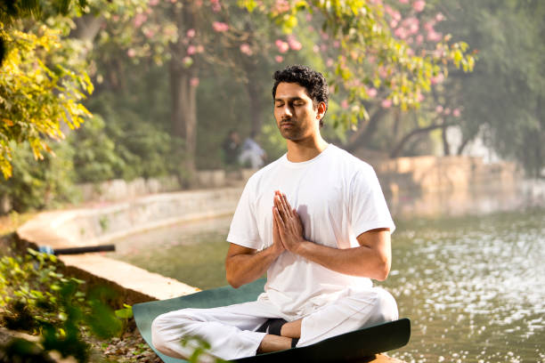 istock Man in yoga pose at park 1292399554