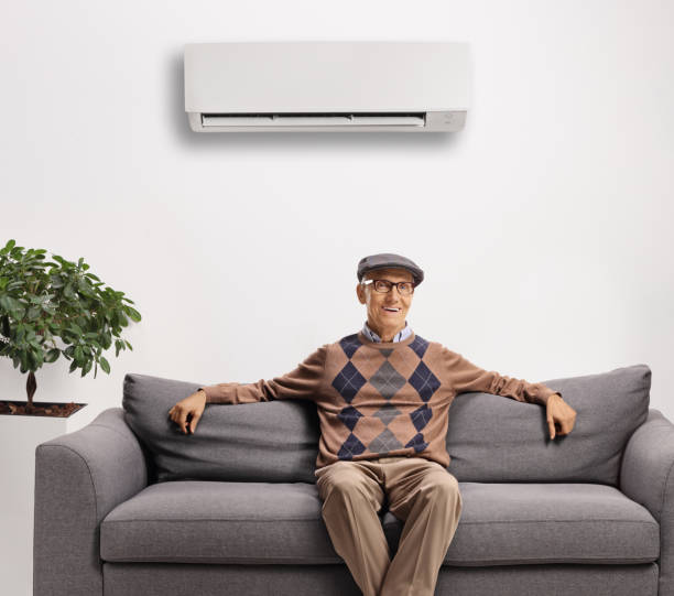 istock Elderly man resting on a gray sofa under an air conditioning unit 1292399810