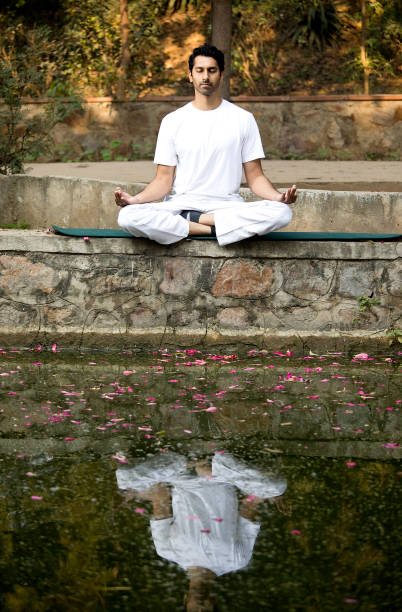 istock Man meditating at lakeshore 1292401004