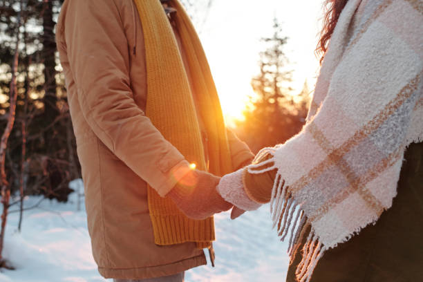 istock Side view of young affectionate and amorous dates in winterwear holding by hands 1292401801