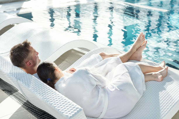 istock Tired young brunette woman in white bathrobe keeping head on husband shoulder 1292402321