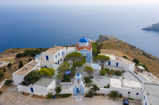 Greece. Kea island, Kastriani monastery, blue sea background. Aerial drone view of church and whitewashed buildings