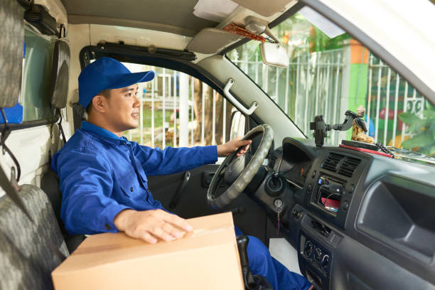 courier driving delivery truck - postal worker truck driver delivering delivery person imagens e fotografias de stock