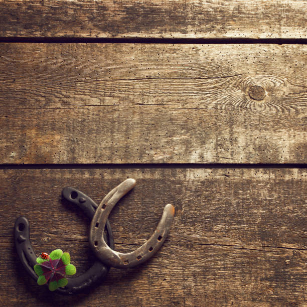istock Horseshoe with lucky clover on a wooden background 1292402697