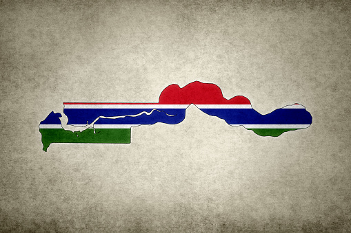 Grunge map of The Gambia with its flag printed within its border on an old paper.