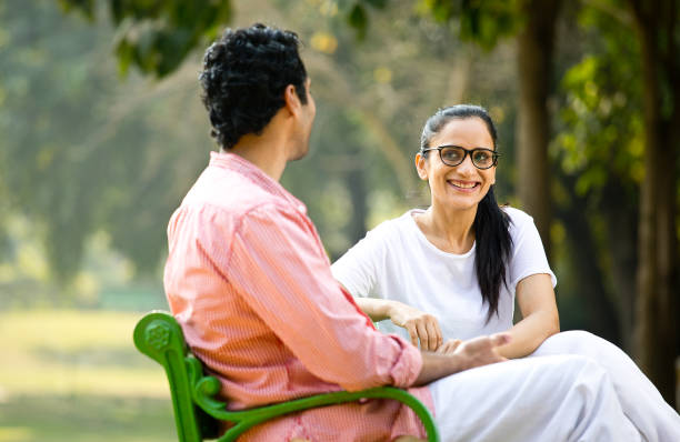 istock Couple looking at each other on park bench 1292403348