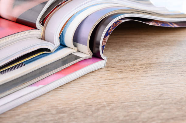 istock Stack of magazines on wooden table. 1292404723