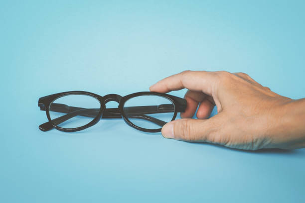 istock human's hand holding eye glasses on blue background 1292405570