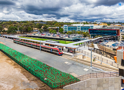 Adelaide, Australia - Dec 21, 2020: Aerial view of electric train at new Flinders Railway Station on the A$141m Flinders Link extension of the former Tonsley Line. In the background is the Flinders Medical Centre and Flinders University. Wide angle view