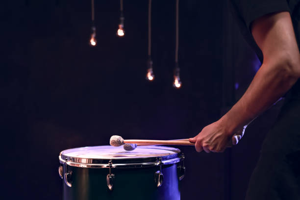 istock The drummer plays with mallets on floor tom in dark room. 1292406880