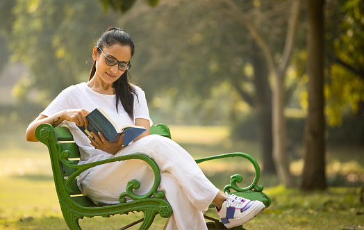 Beautiful woman reading a book at park