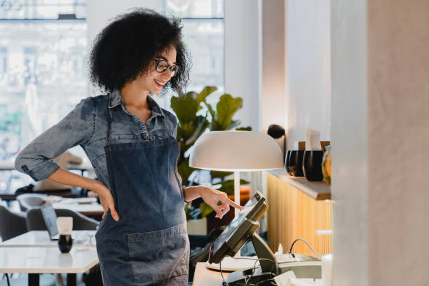 serveuse afro-américaine des années 20 travaillant au point de caisse dans la cafétéria spacieuse - point de vente photos et images de collection