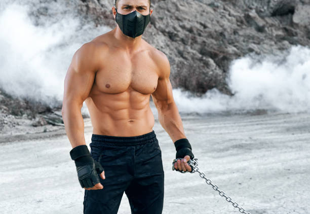 istock Bodybuilder in protective mask standing at sand quarry 1292407027