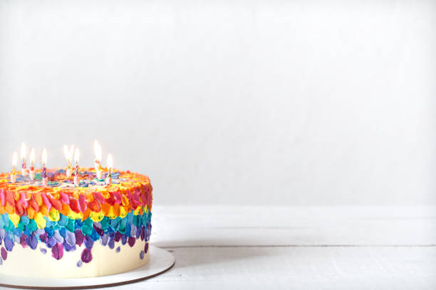 istock Colorful handmade birthday cake with burning candles copy space. 1292407181