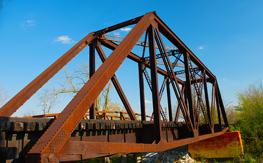 A rusty bridge crossing over the lake in Herman Park